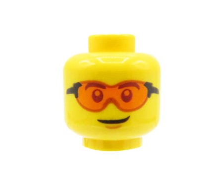 LEGO minifigure head - man, orange sport glasses, lopsided grin.